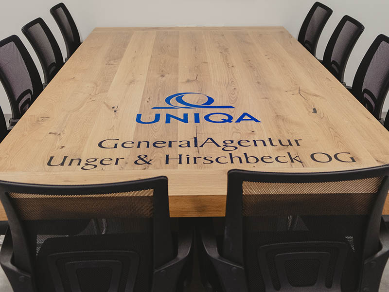 Ein Holztische mit dem Logo der Generalagentur Unger und Hirscheck.